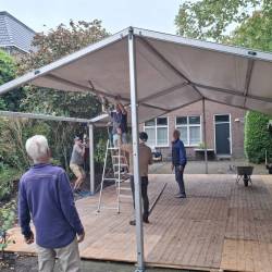 het dak gaat erop, en de opzichter kijkt toe